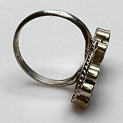 Side view of raised turquoise and red floral inlays in silver setting