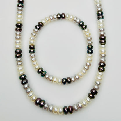 Close-up of matching pearl necklace and stretch bracelet in modern neutral tones