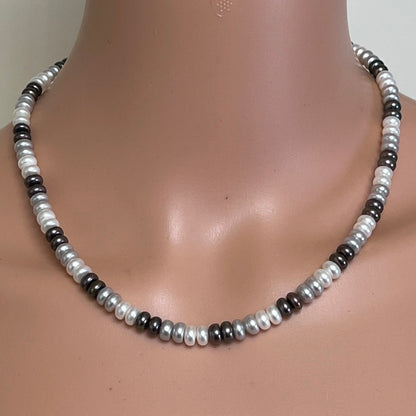 Tri-color cultured pearl necklace worn on mannequin with alternating white, grey, and black pearls