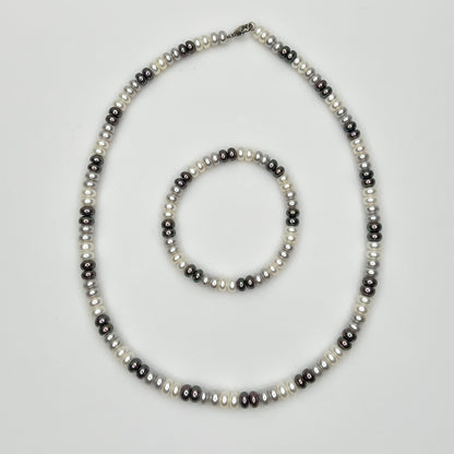 Close-up of matching pearl necklace and stretch bracelet in modern neutral tones