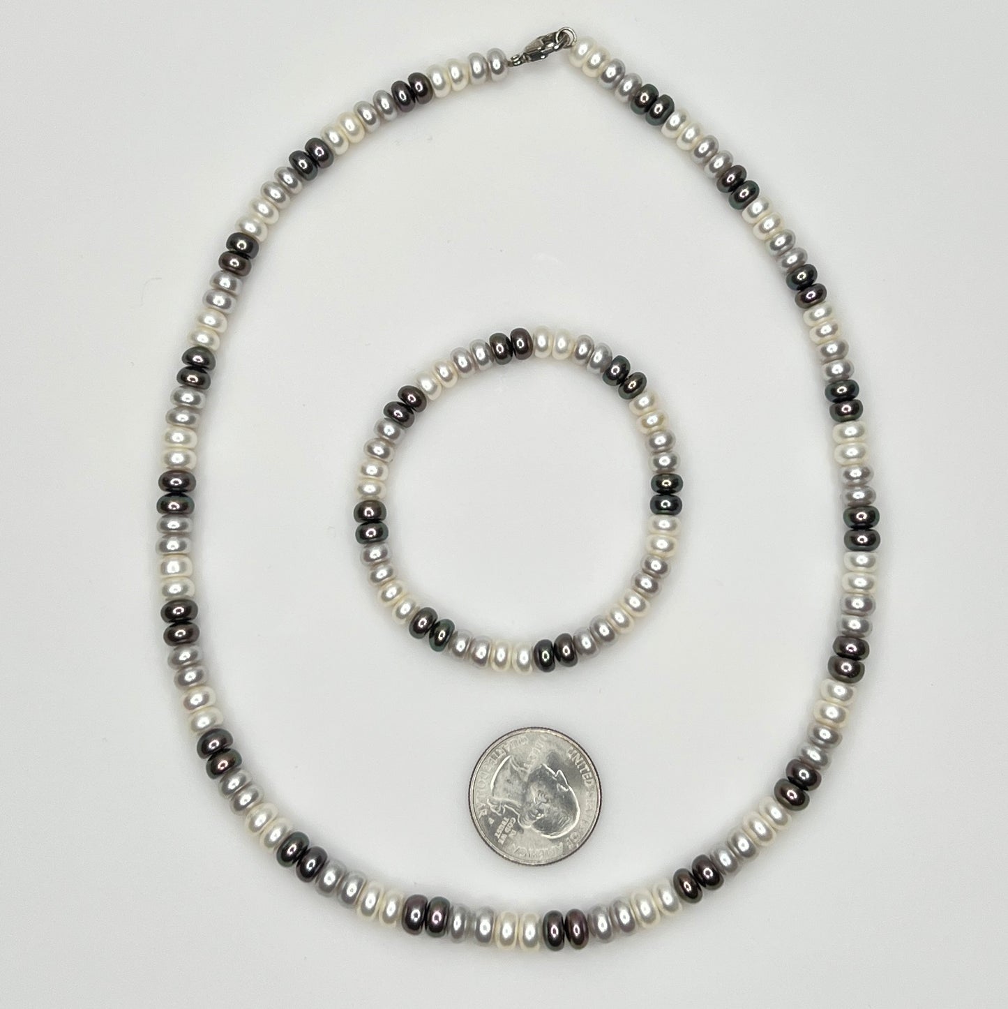 Close-up of matching pearl necklace and stretch bracelet in modern neutral tones