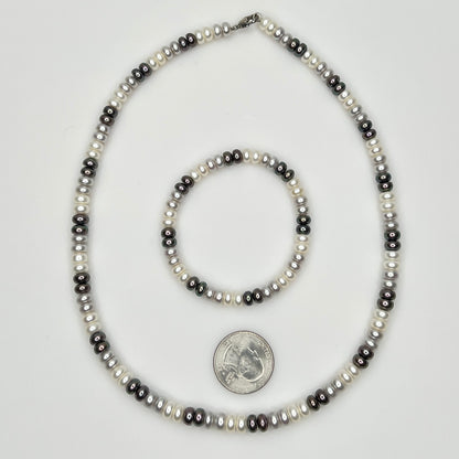 Close-up of matching pearl necklace and stretch bracelet in modern neutral tones