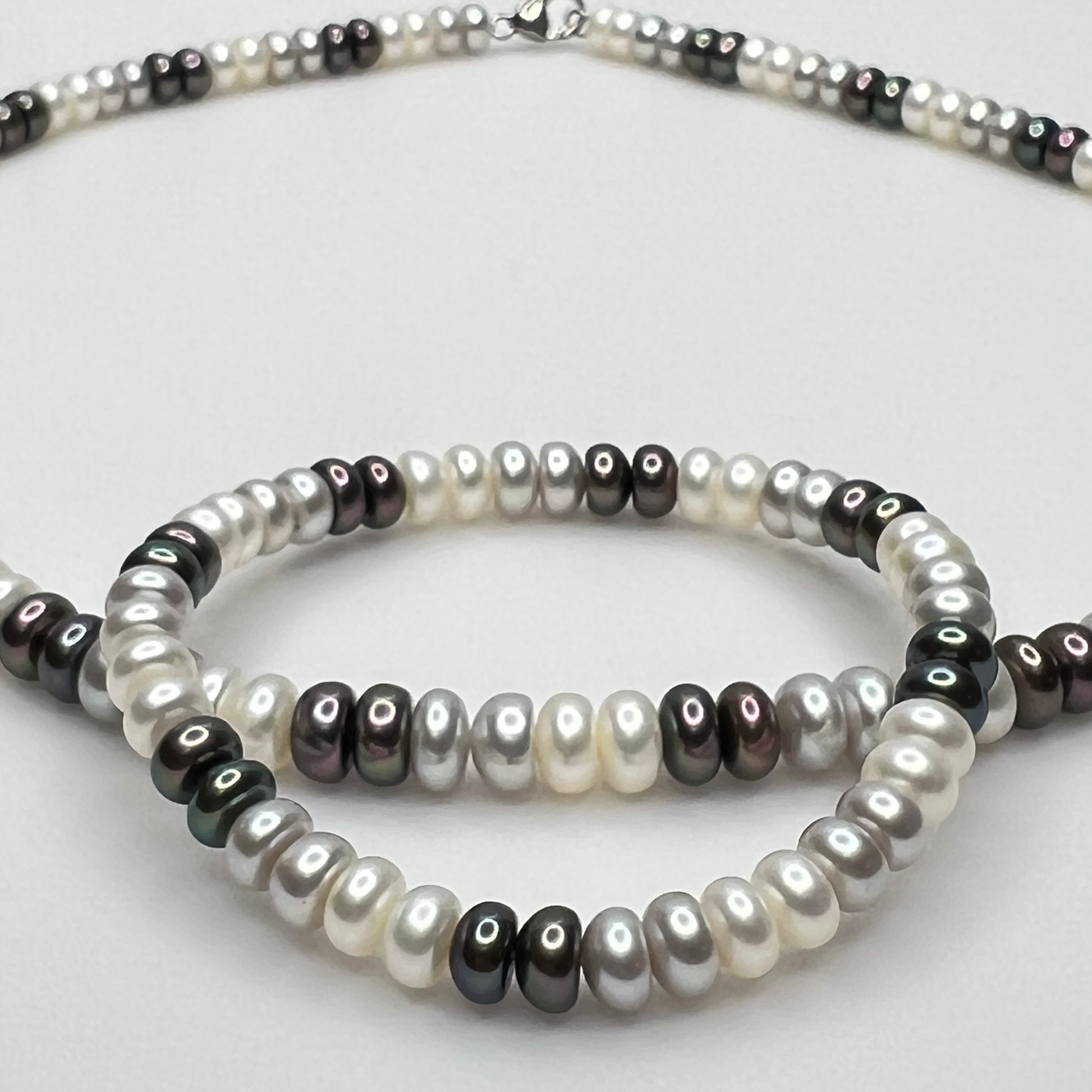 Close-up of matching pearl necklace and stretch bracelet in modern neutral tones