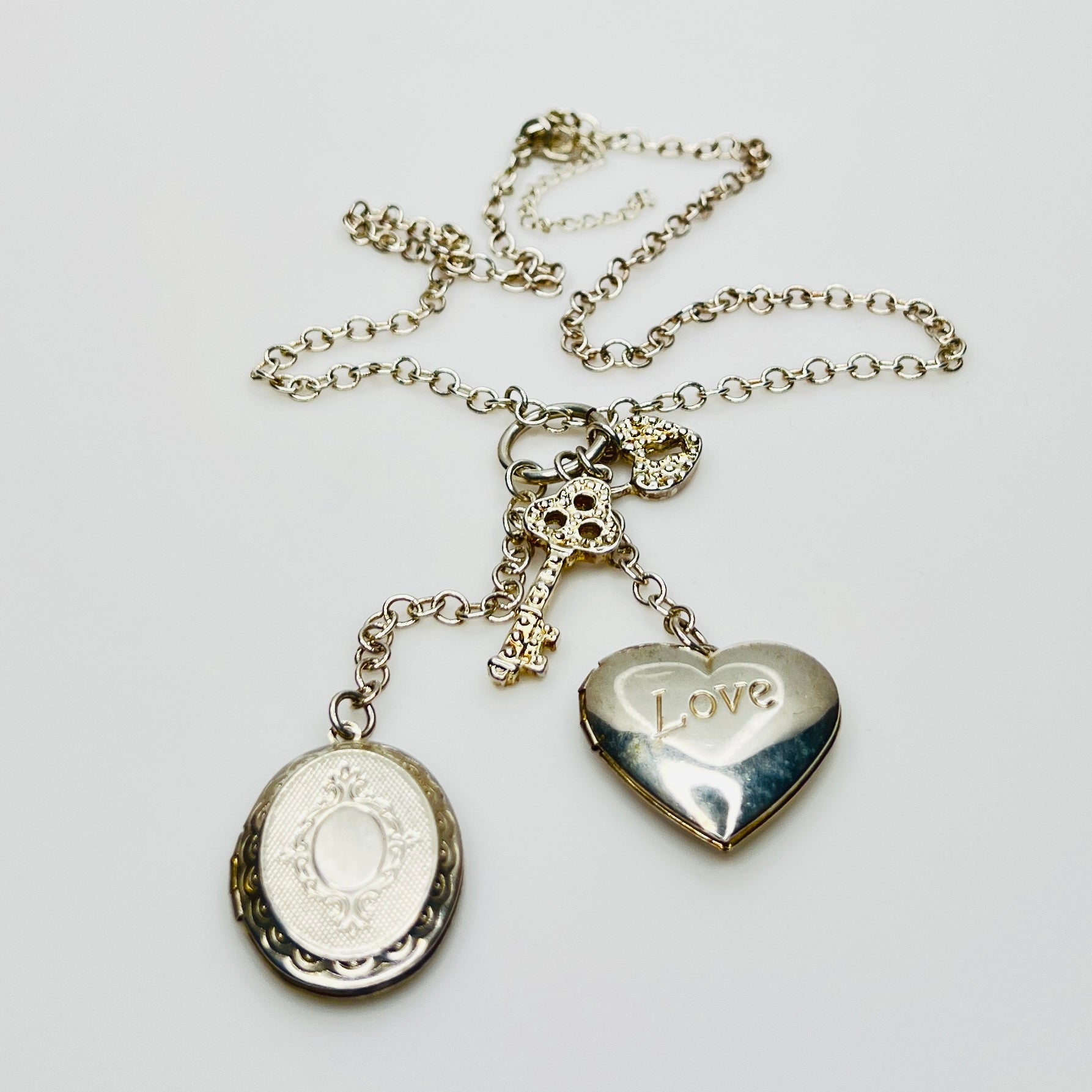 Sterling silver charm necklace with heart and oval lockets