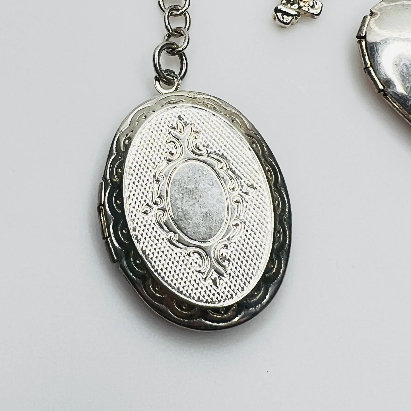 Ornate oval sterling silver locket charm detail