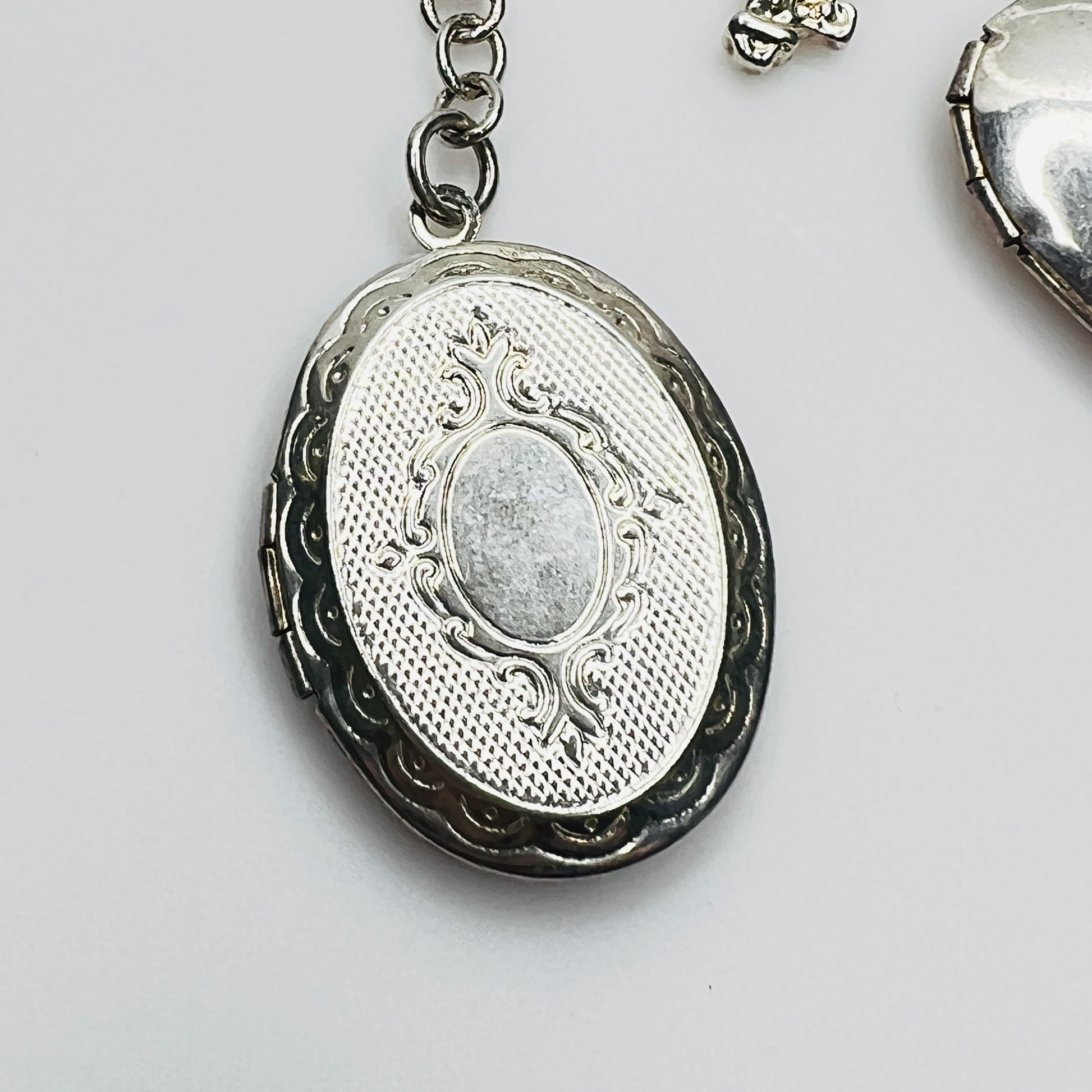 Ornate oval sterling silver locket charm detail