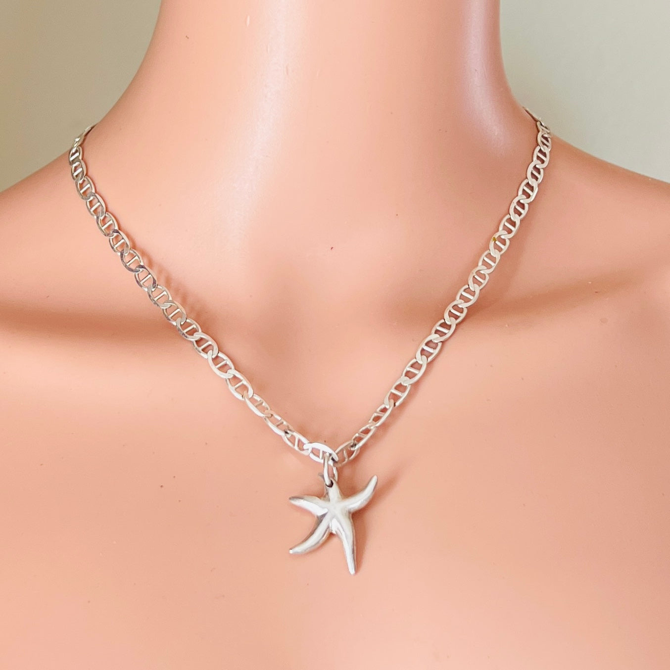 Starfish pendant necklace worn on mannequin silver nautical chain