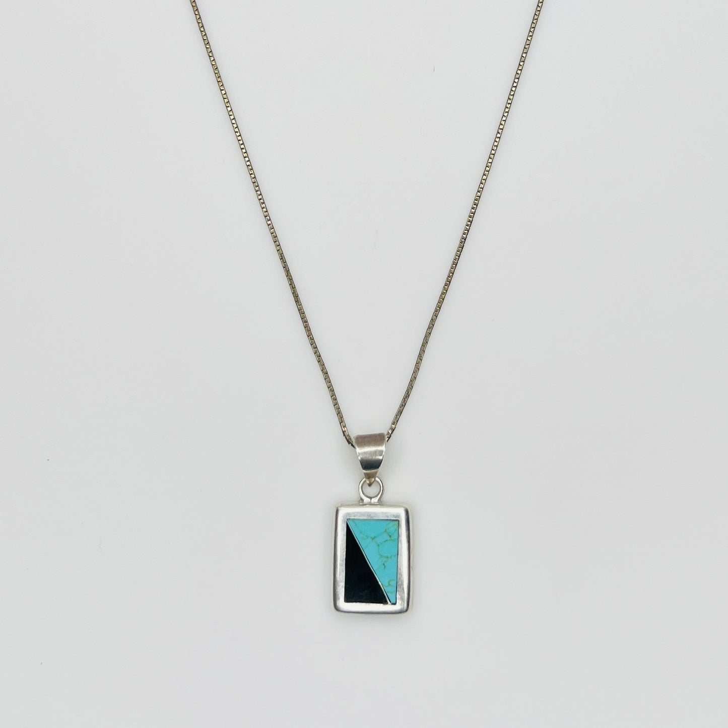 Detail of sterling pendant with turquoise and black onyx inlay