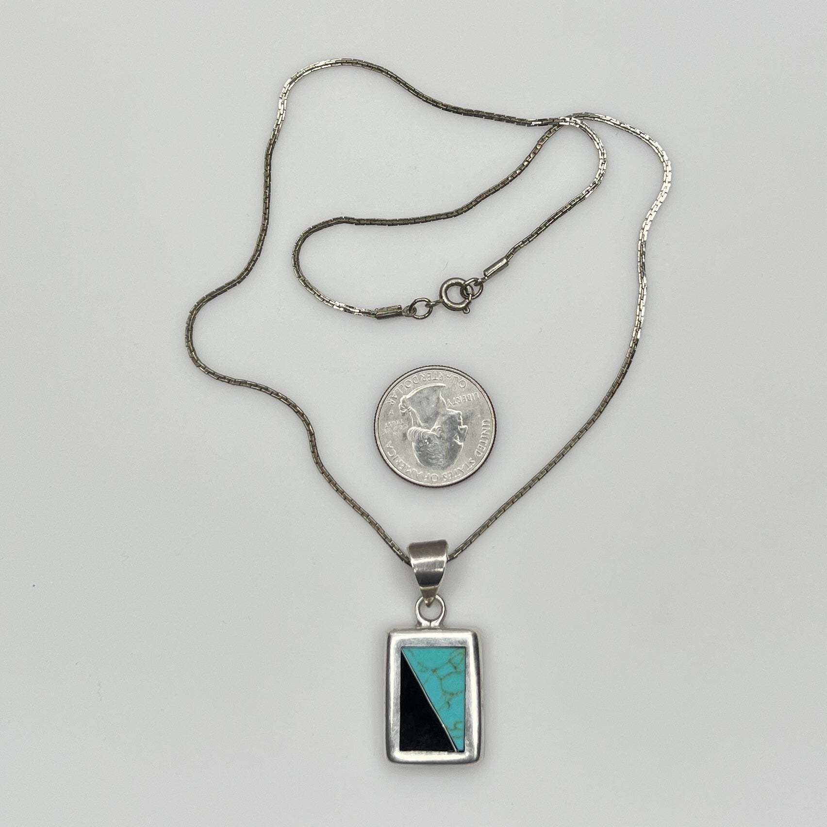 Full view of geometric inlay pendant on chain