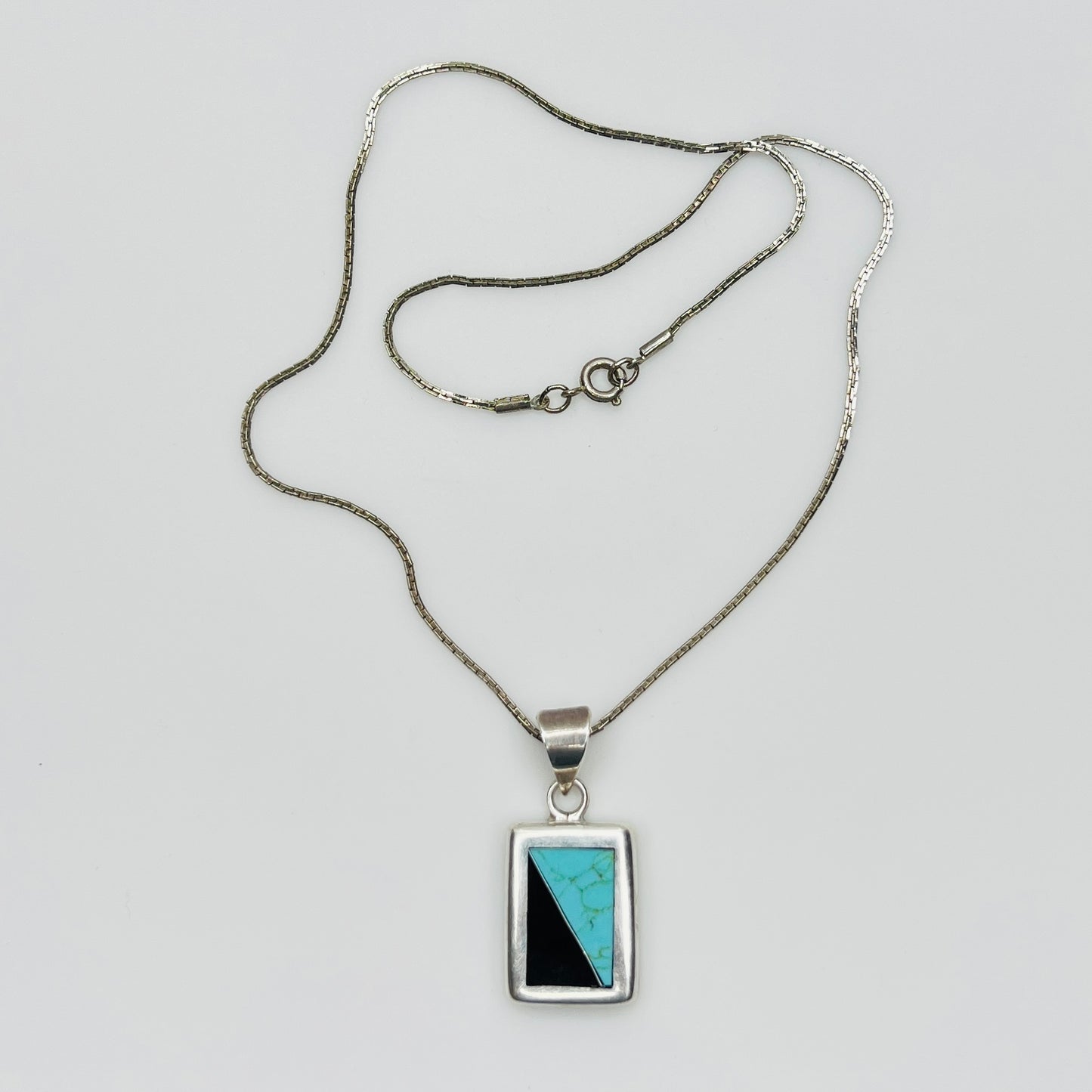 Full view of geometric inlay pendant on chain