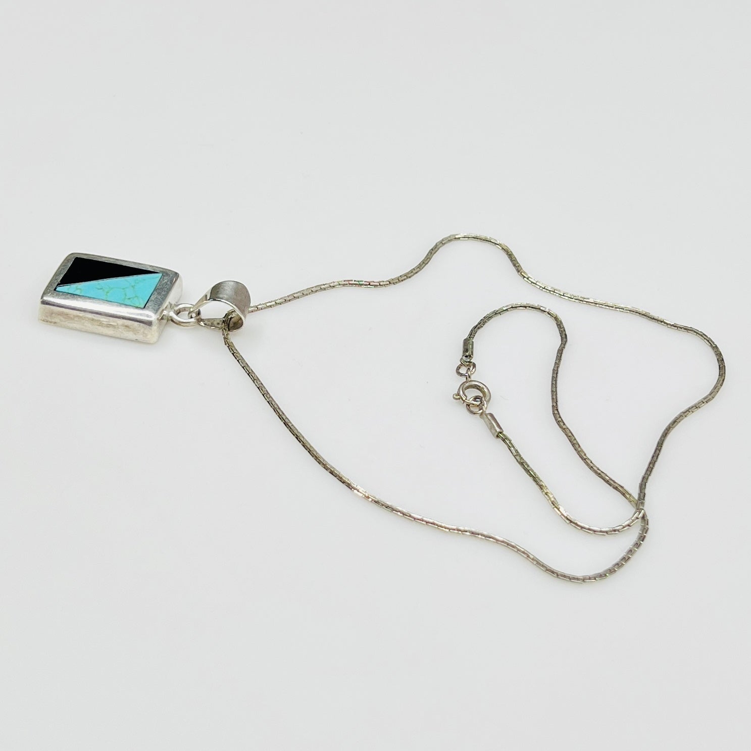 Full view of geometric inlay pendant on chain