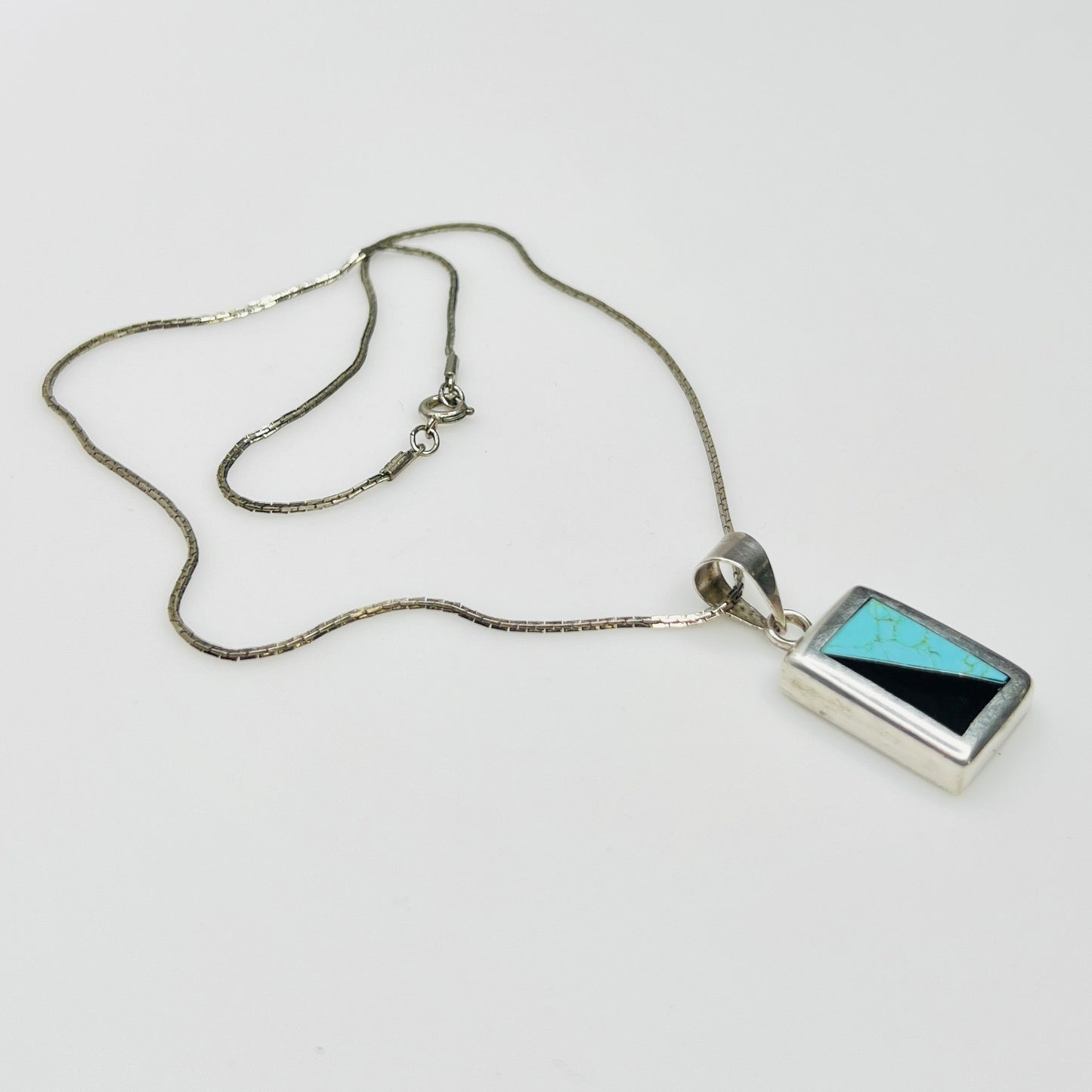 Full view of geometric inlay pendant on chain