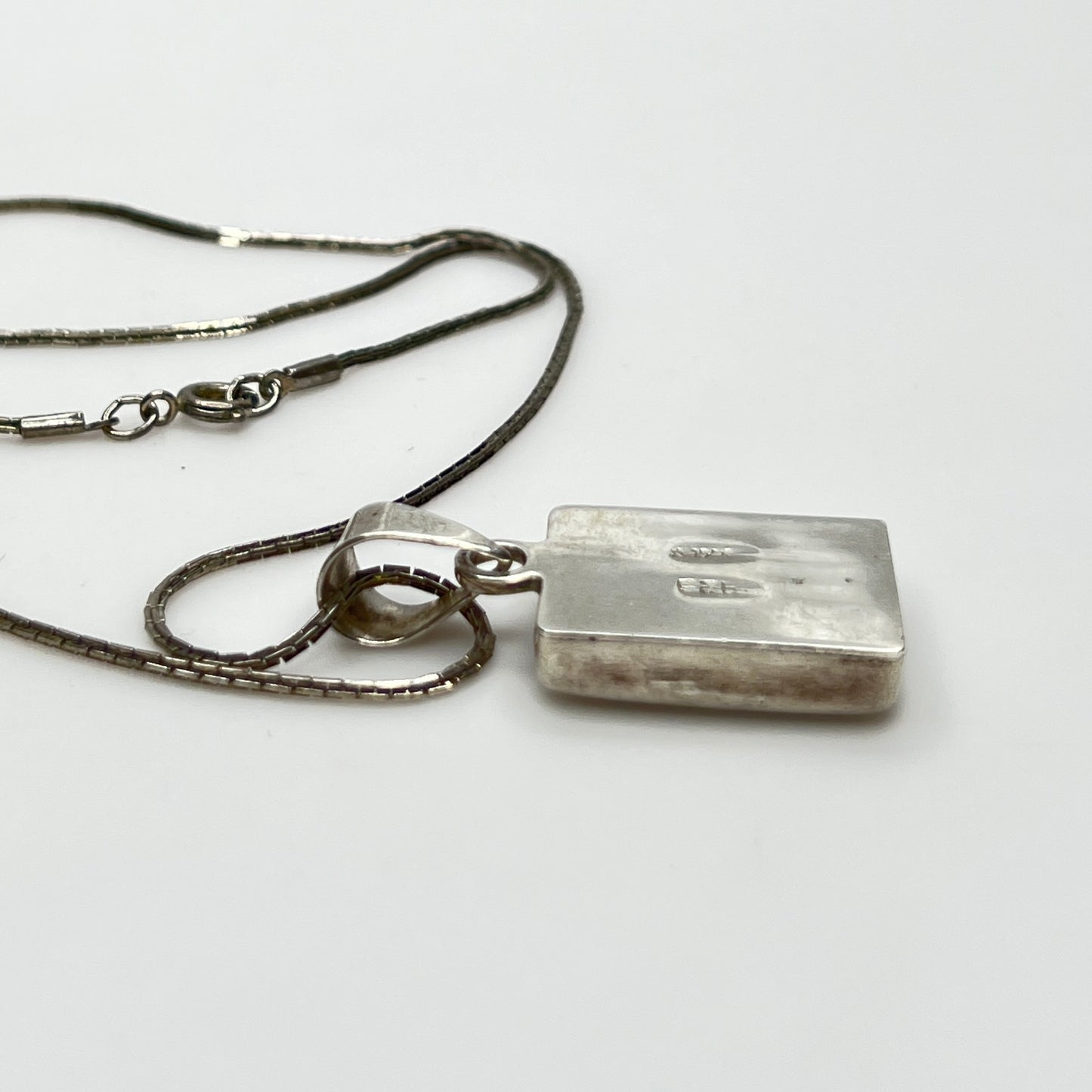 side view of geometric inlay pendant on chain