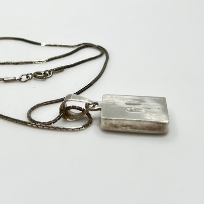 side view of geometric inlay pendant on chain