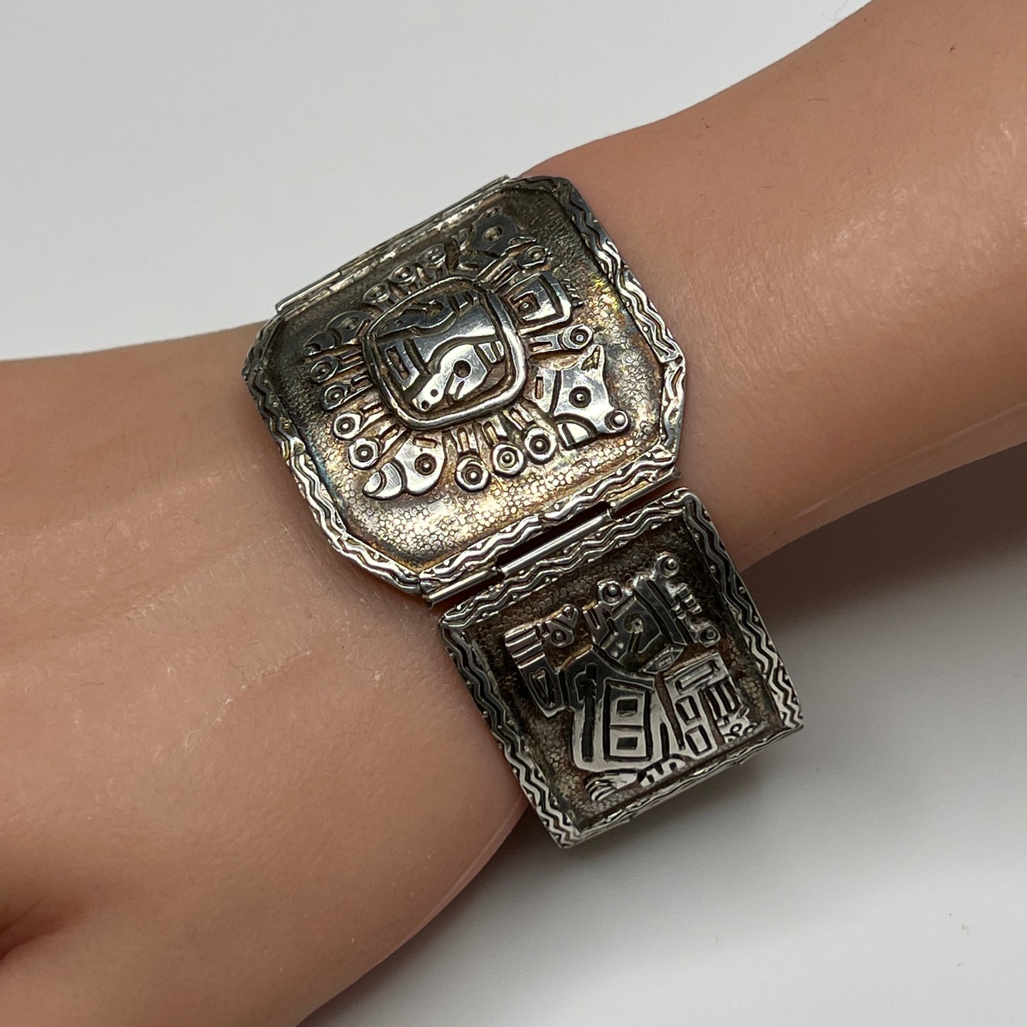 Side view of bracelet panels featuring etched ancient warrior and animal symbols