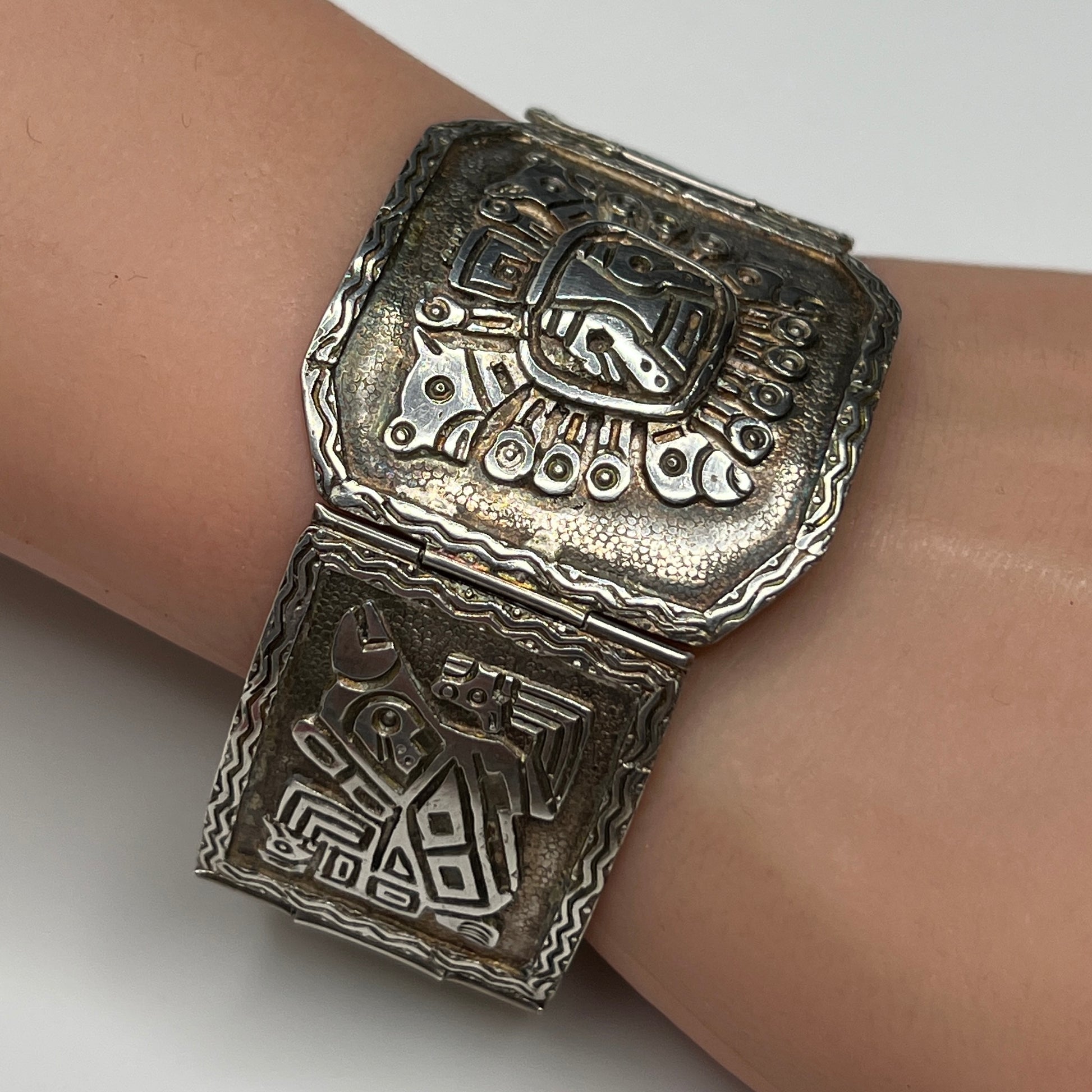 Side view of bracelet panels featuring etched ancient warrior and animal symbols