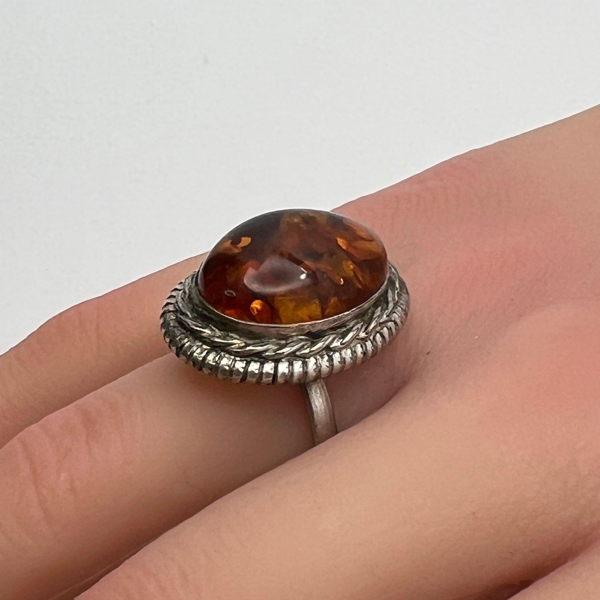 Sterling silver ring with oval amber cabochon and rope bezel