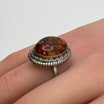 Sterling silver ring with oval amber cabochon and rope bezel