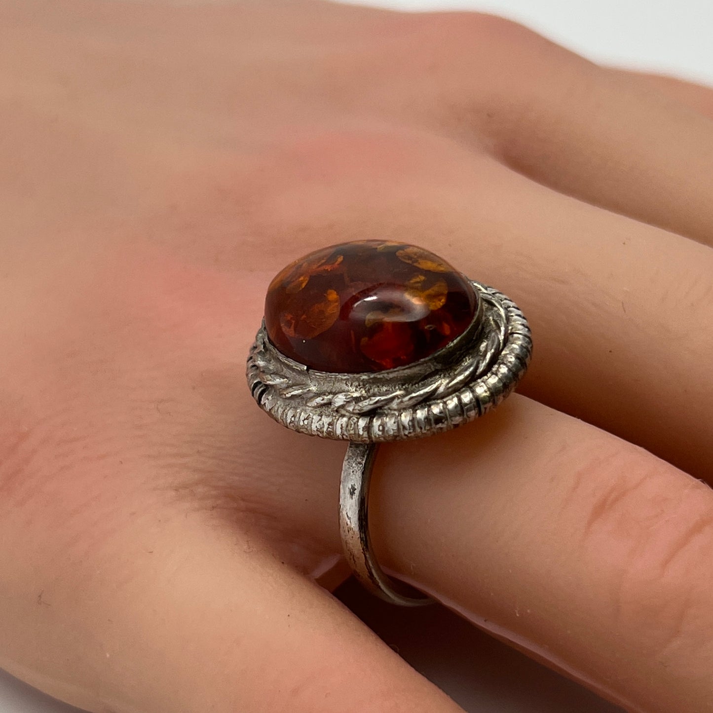 Sterling silver ring with oval amber cabochon and rope bezel
