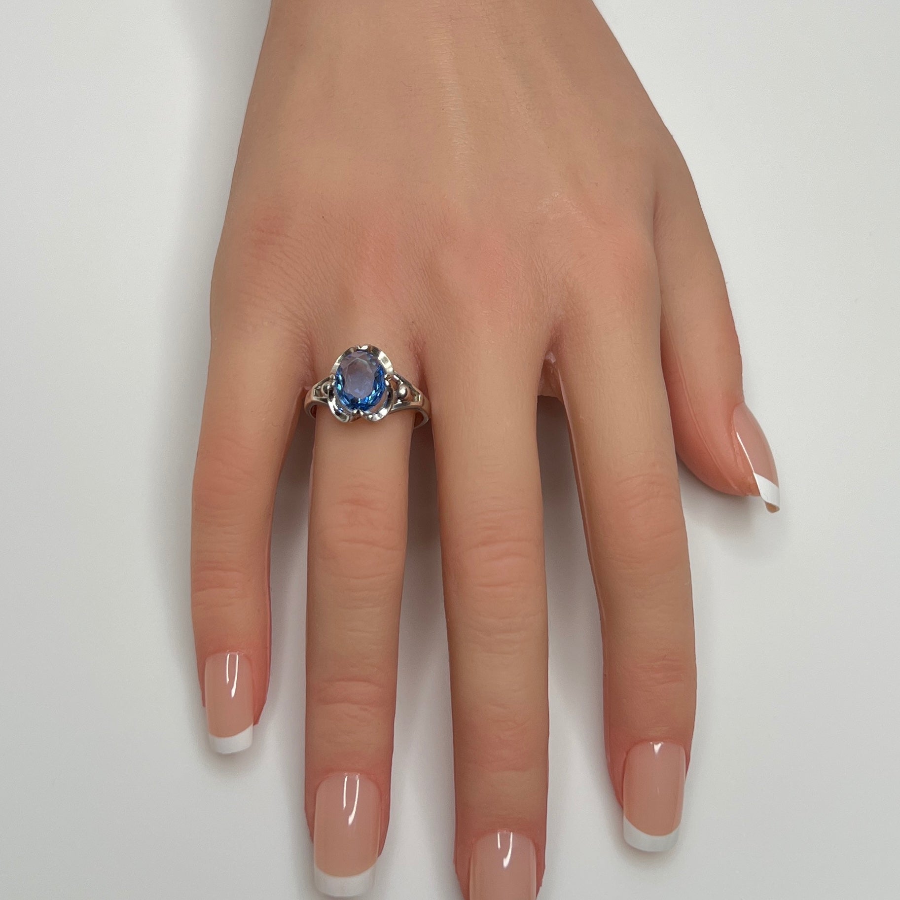 Sterling silver ring with oval blue topaz worn on hand