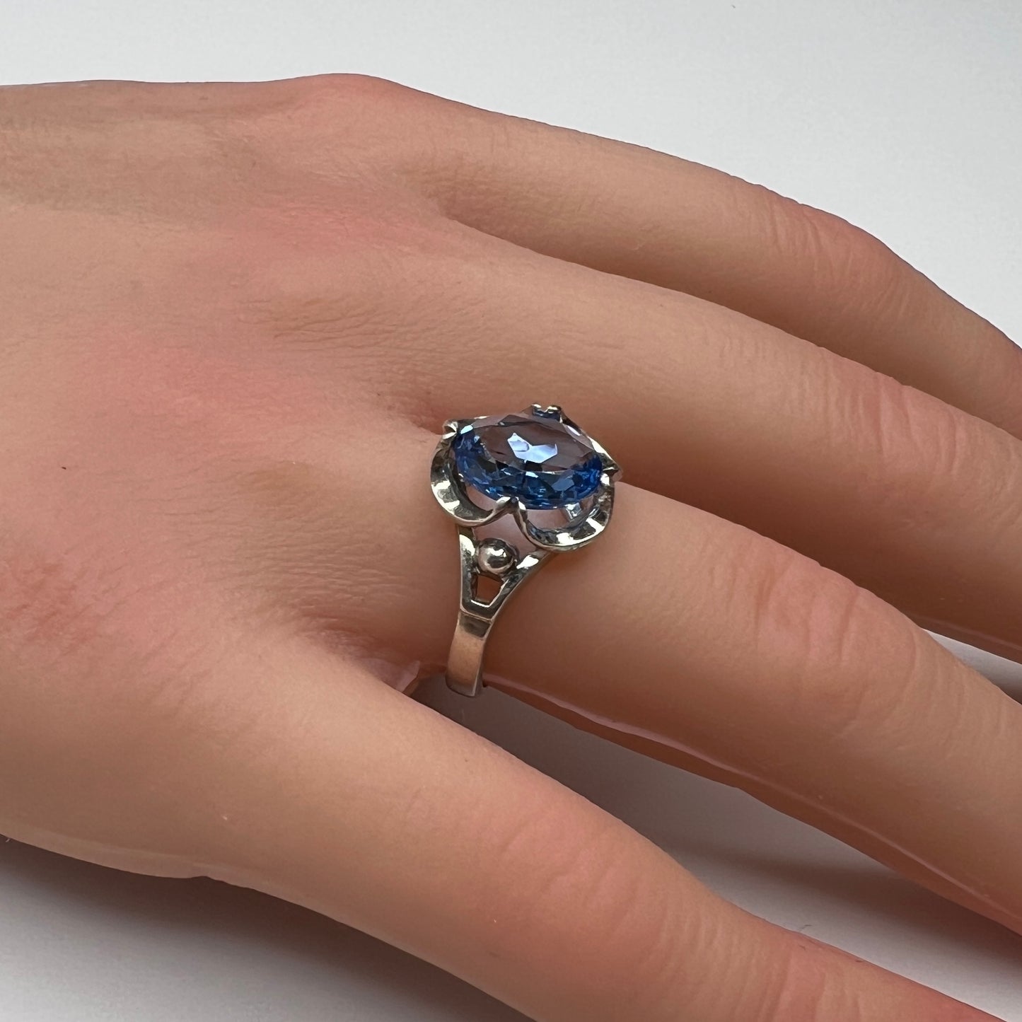 Sterling silver ring with oval blue topaz worn on hand