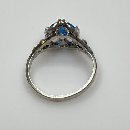 Close-up of vintage silver ring showing blue topaz and sculptural setting