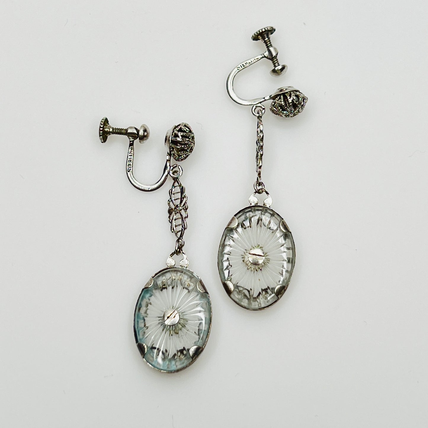 Reverse of earrings showing starburst cut camphor glass backs
