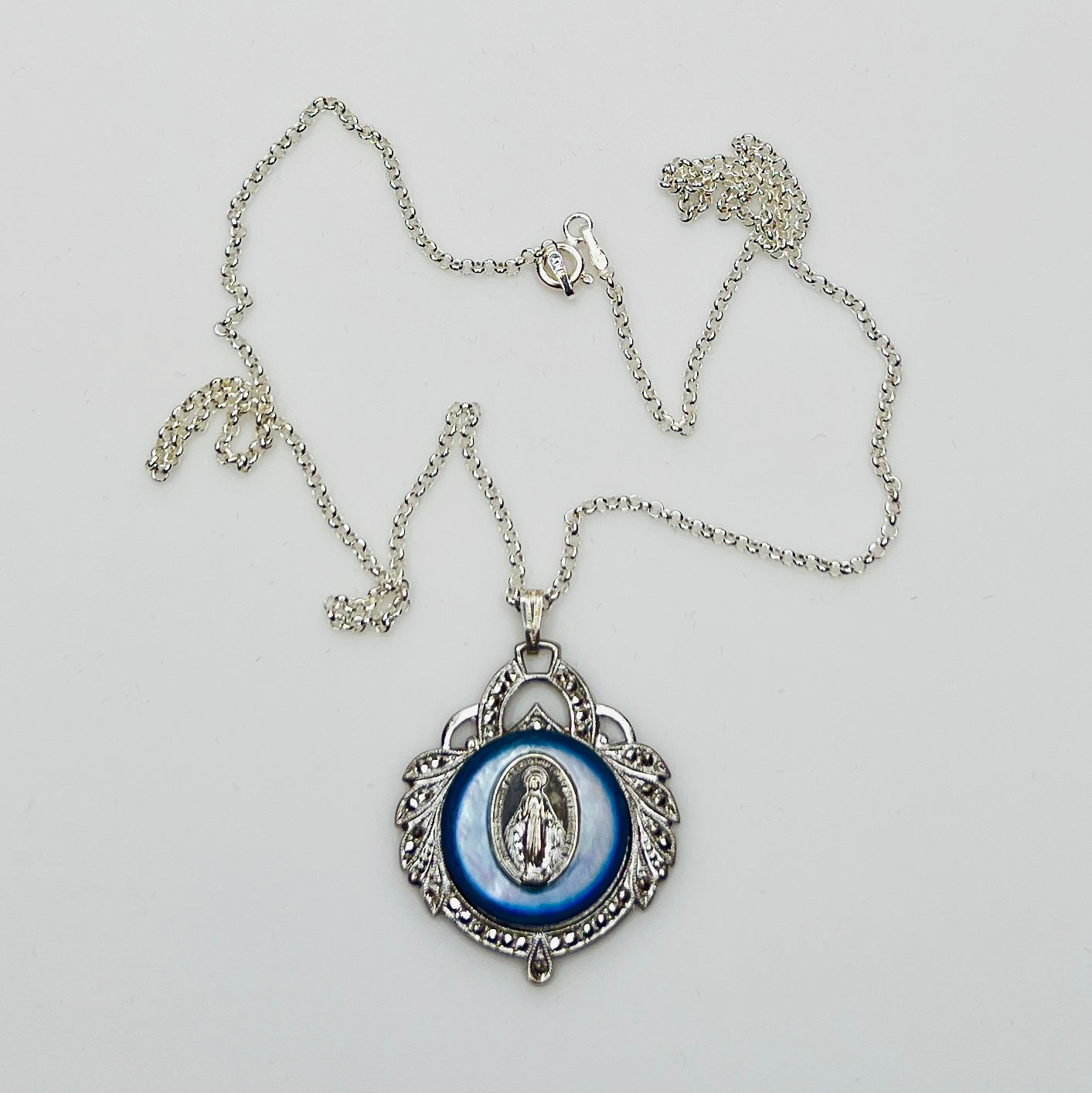 Close-up of marcasite Virgin Mary pendant with mother of pearl center