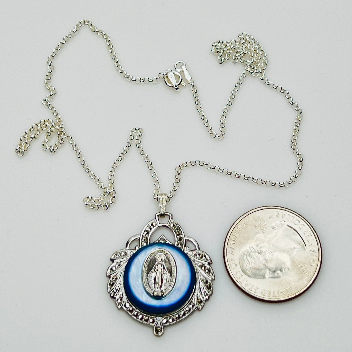 Close-up of marcasite Virgin Mary pendant with mother of pearl center