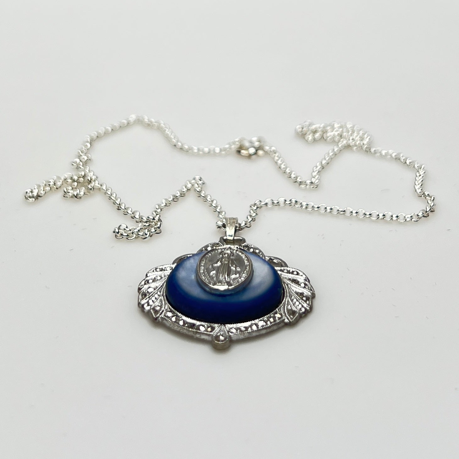 Close-up of marcasite Virgin Mary pendant with mother of pearl center