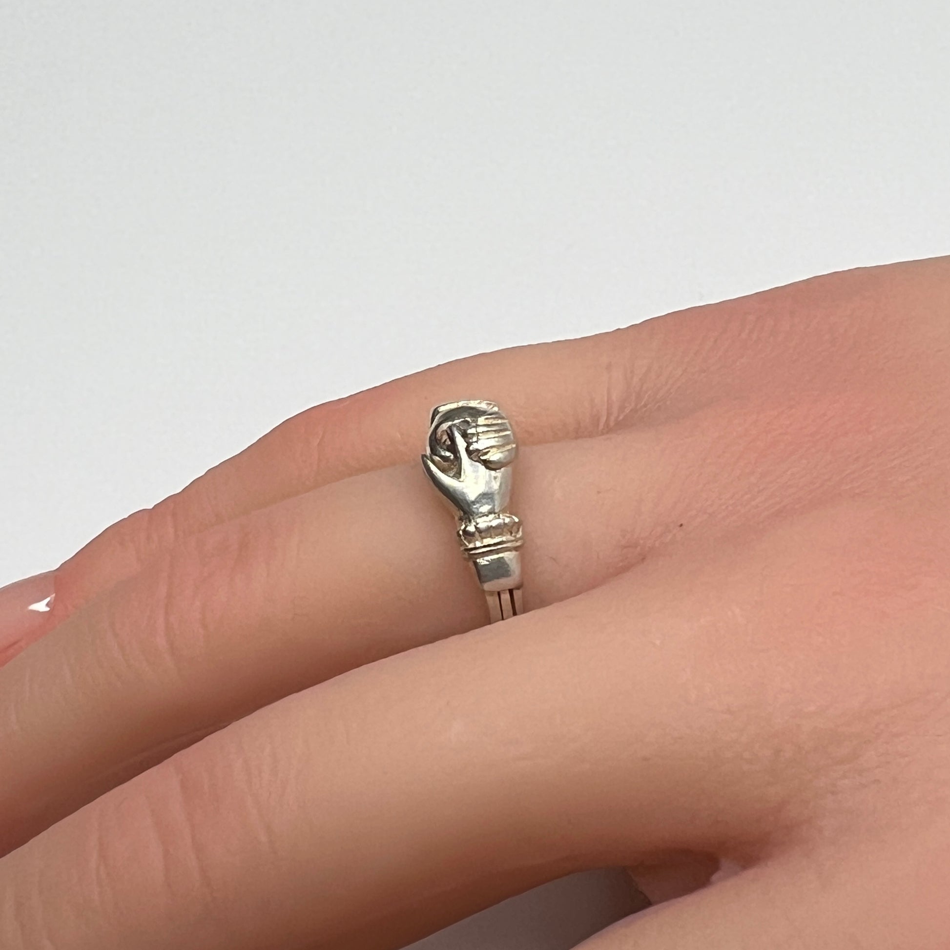 Celtic puzzle ring shown worn on hand with interlocking bands closed