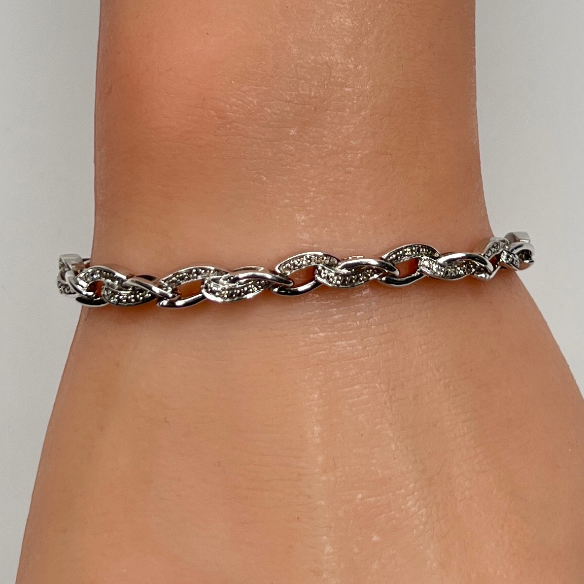 Sterling silver diamond link bracelet worn on wrist