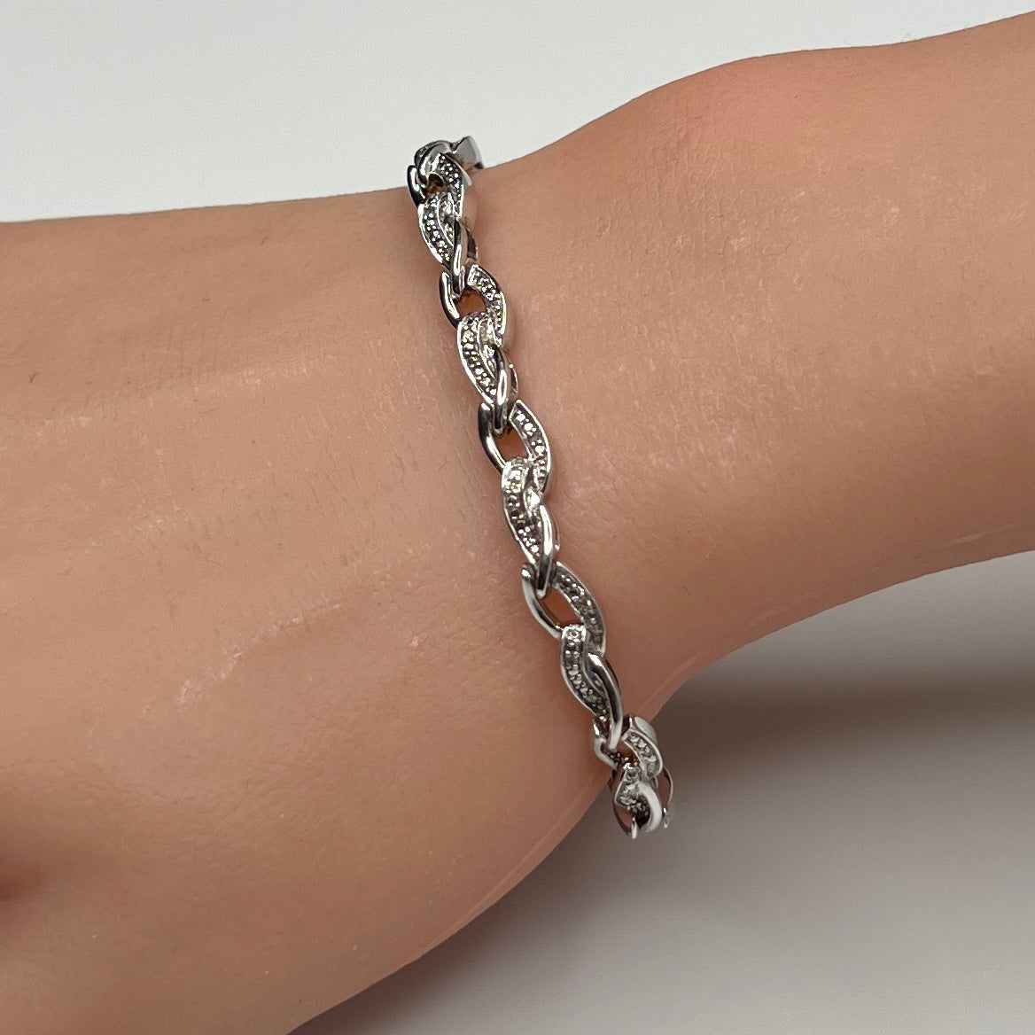 Sterling silver diamond link bracelet worn on wrist