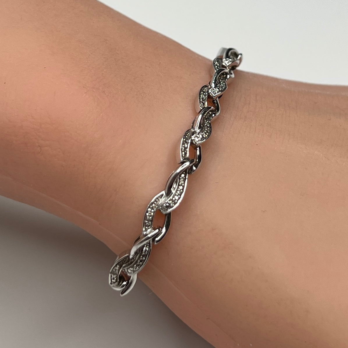 Sterling silver diamond link bracelet worn on wrist