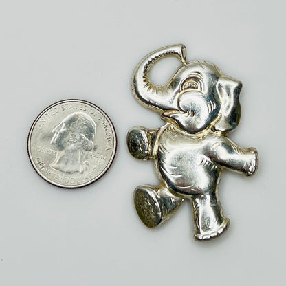 Sterling silver brooch shaped like a walking elephant with raised trunk and rounded limbs