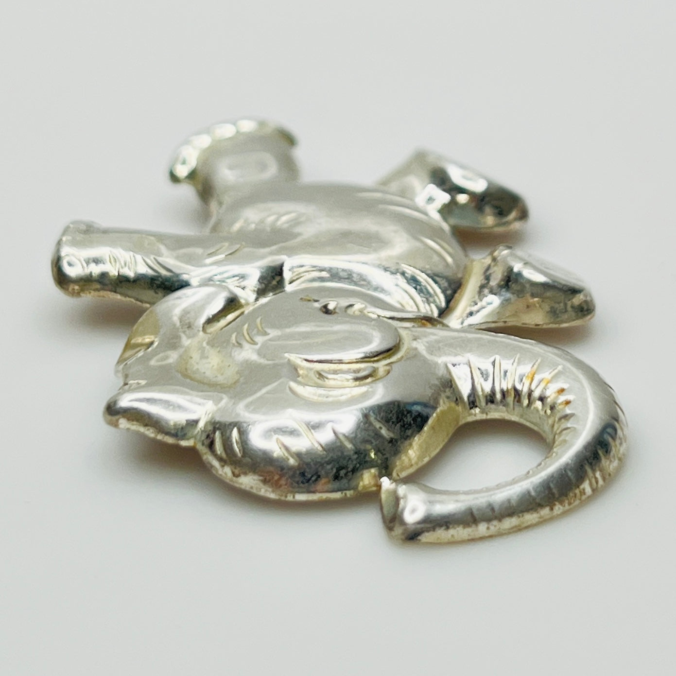 Sterling silver brooch shaped like a walking elephant with raised trunk and rounded limbs