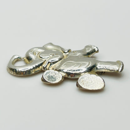 Sterling silver brooch shaped like a walking elephant with raised trunk and rounded limbs