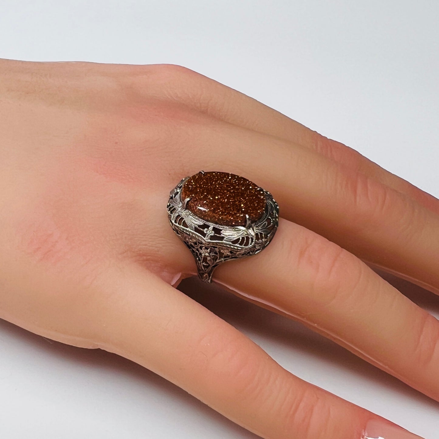 Vintage sterling silver ring with glittering goldstone cabochon and filigree setting
