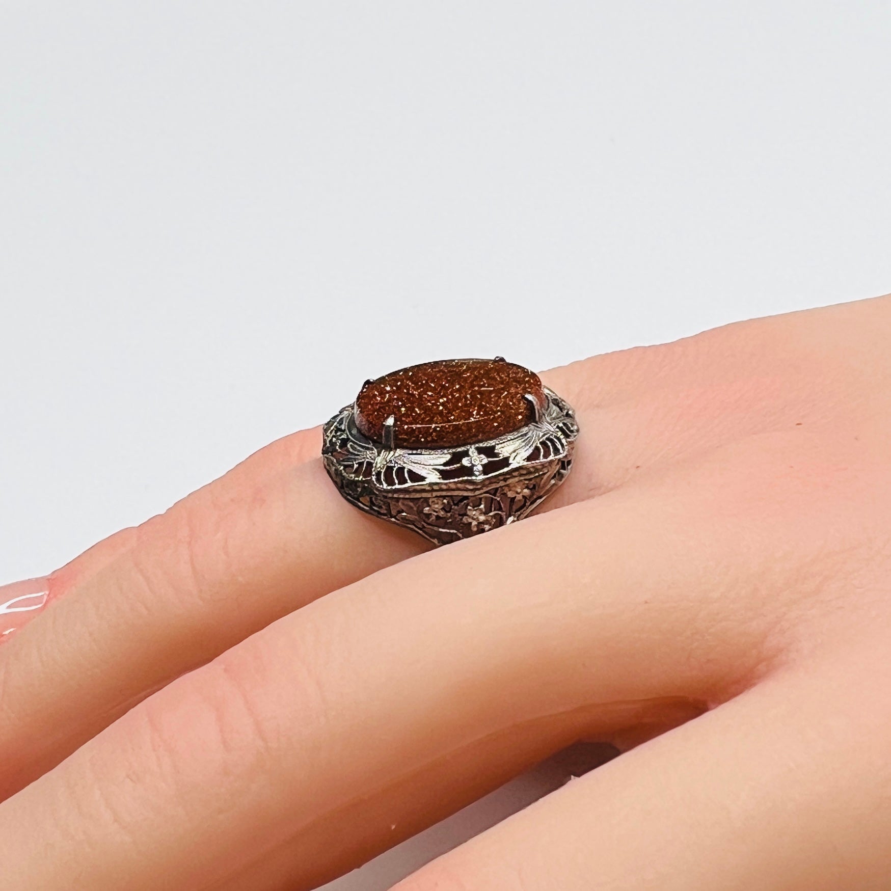 Vintage sterling silver ring with glittering goldstone cabochon and filigree setting