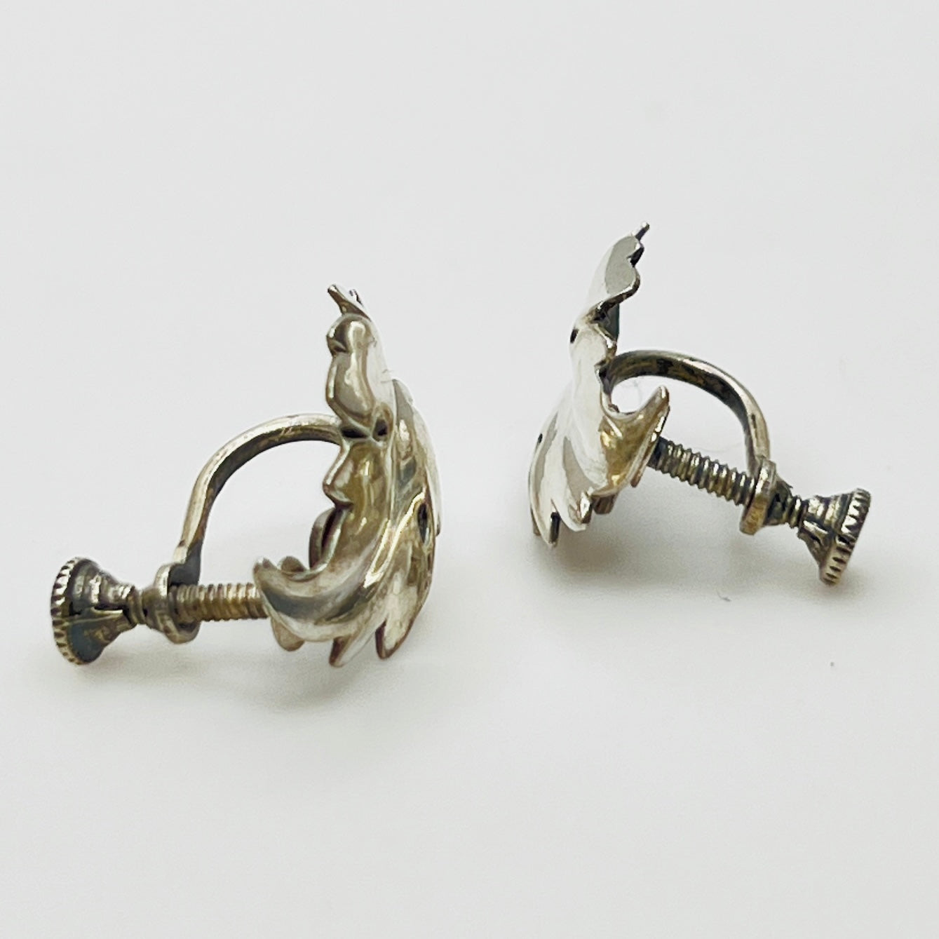 Side angle showing screw-back earring hardware and curved leaf shape
