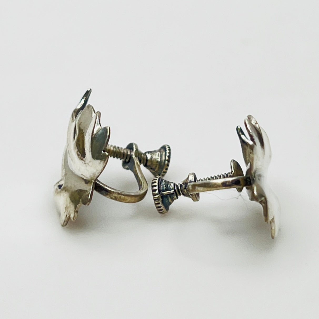 Side angle showing screw-back earring hardware and curved leaf shape