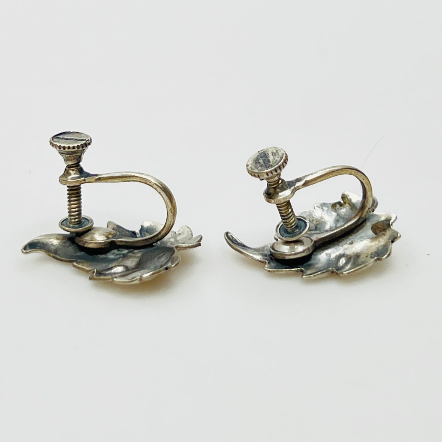 Side angle showing screw-back earring hardware and curved leaf shape