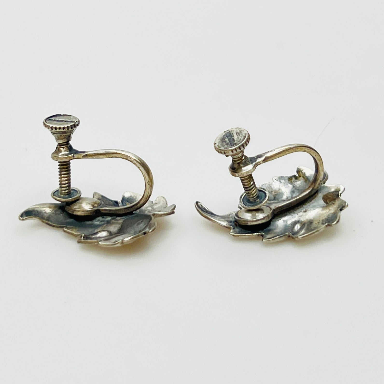 Side angle showing screw-back earring hardware and curved leaf shape