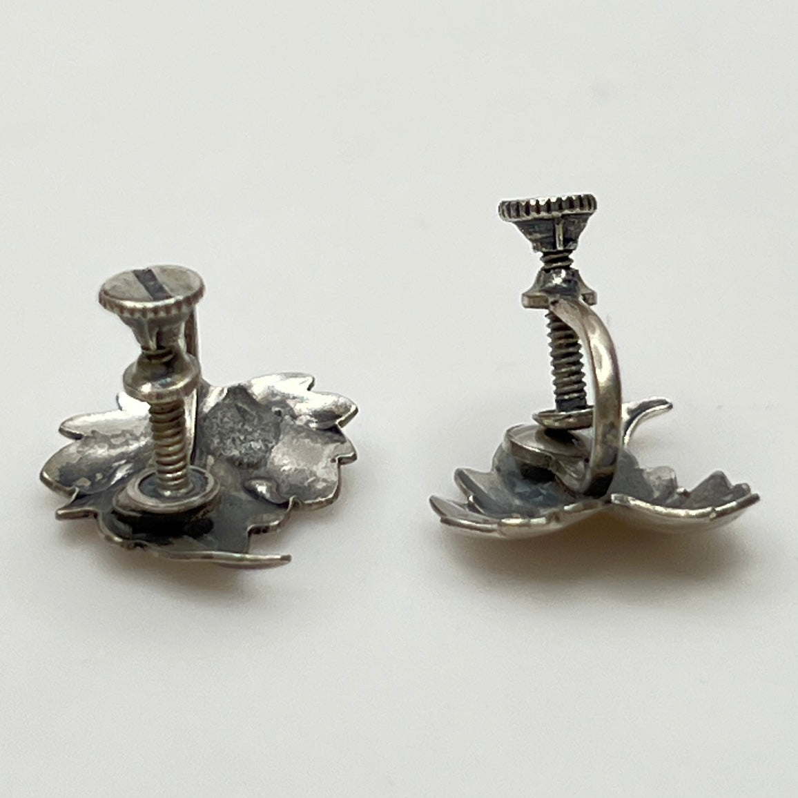 Side angle showing screw-back earring hardware and curved leaf shape
