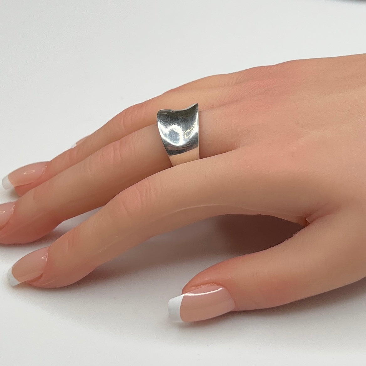 Sterling silver modernist band ring on hand with tapered shape