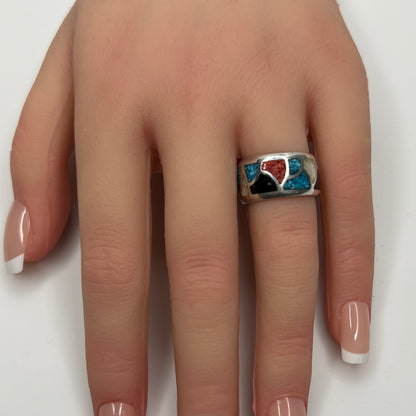 Sterling silver mosaic ring with turquoise, coral, onyx, and mother-of-pearl inlay on model’s hand