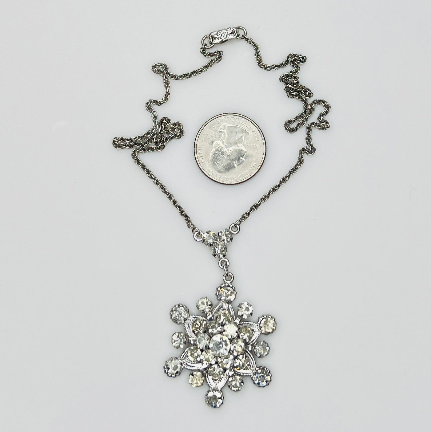 Close-up of clear rhinestone floral pendant in sterling silver setting