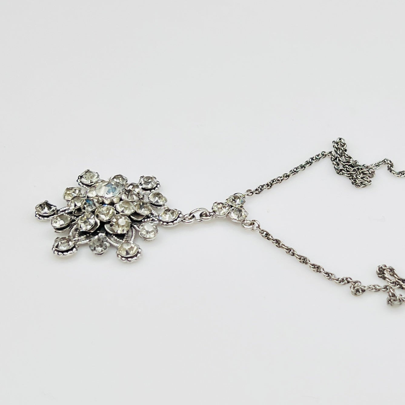 Close-up of clear rhinestone floral pendant in sterling silver setting