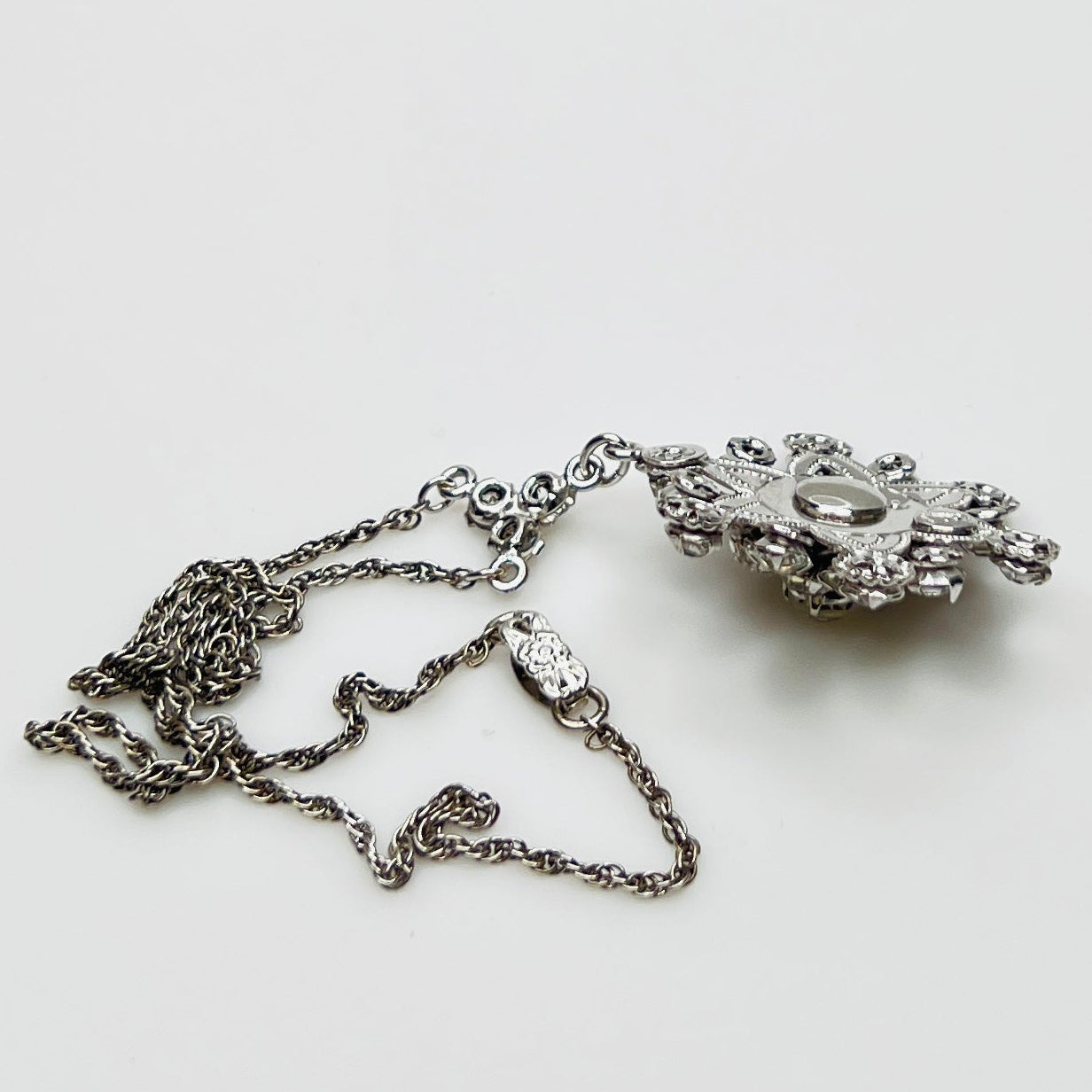 Close-up of clear rhinestone floral pendant in sterling silver setting