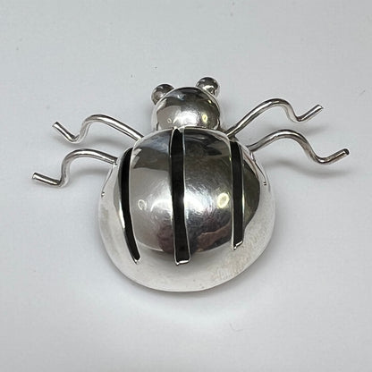 Sterling silver spider brooch with stylized body and curved legs